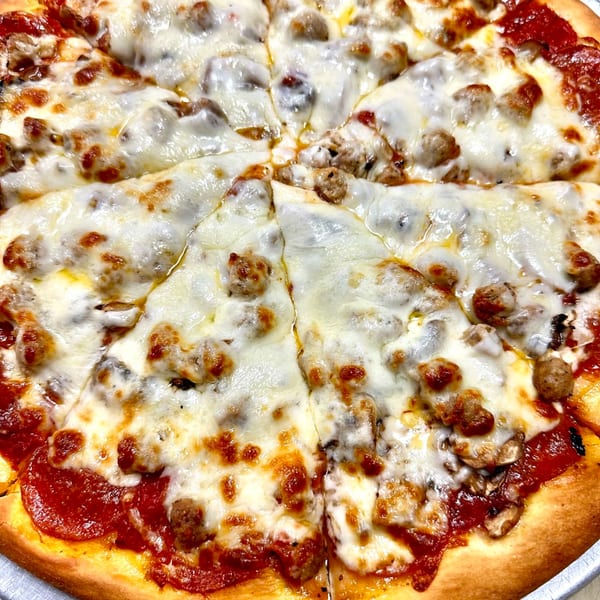 Close-up of a Marri's Pizza with melted cheese, pepperoni, and sausage, sliced into wedges.