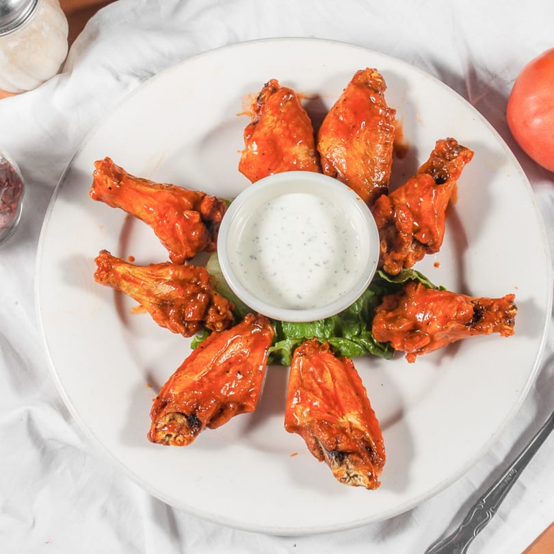 Marri's Pizza Orange's buffalo wings arranged in a circle with a side of ranch dressing.